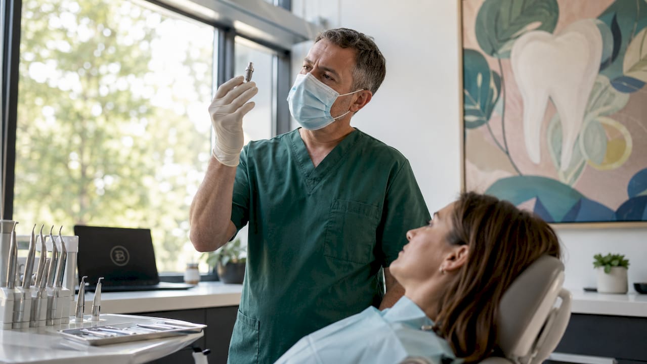 Dental surgeon holding titanium implant in surgery room