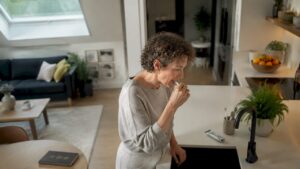 Woman brushing teeth in bathroom side view